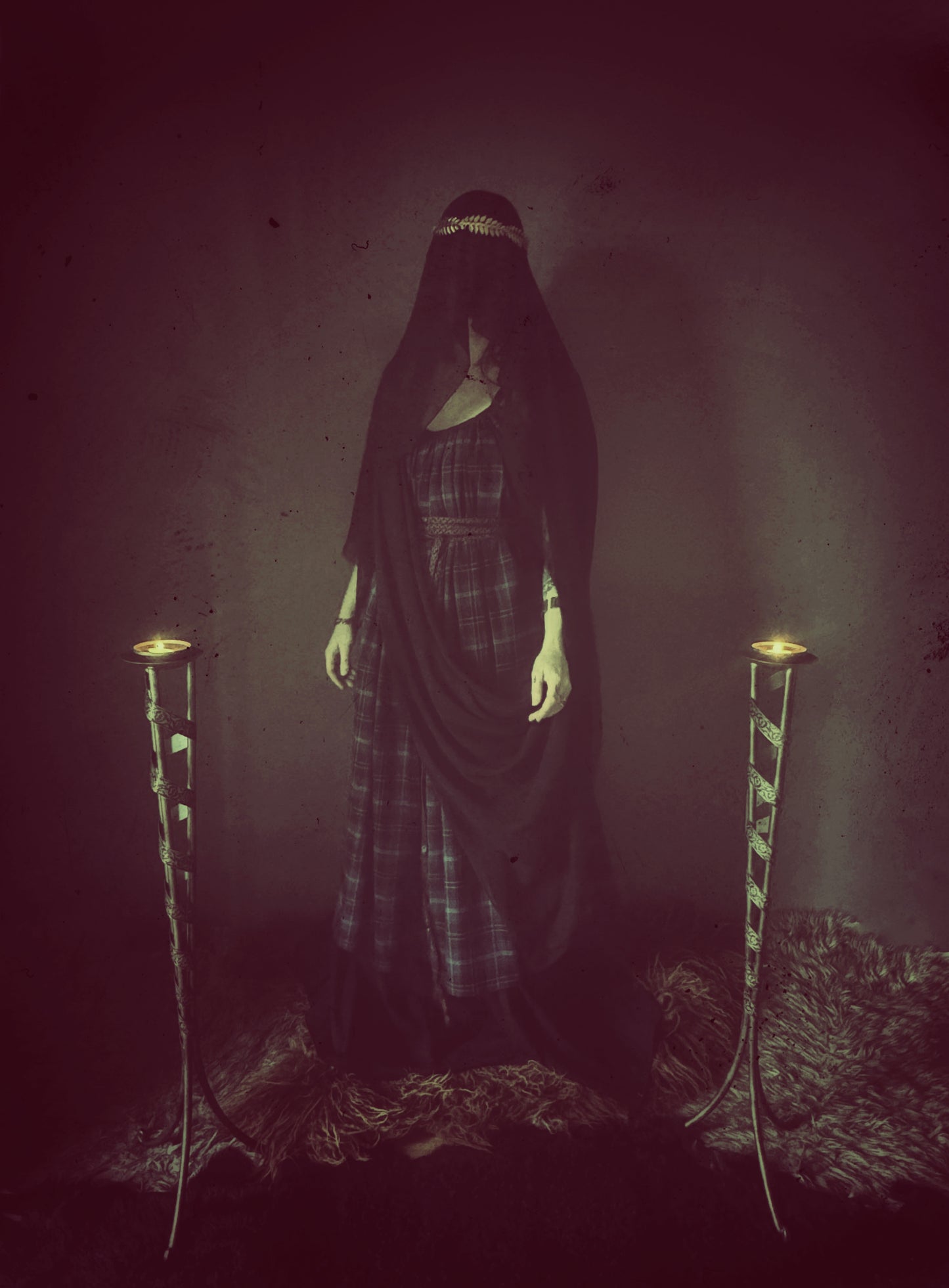 A high priestess stands between two flames. Wearing a tartan dress with a long black veiled wrapped around her body and cover her face. The plaid dress is floor length with adjustable thin shoulder straps featuring side seam pockets and a long thin black wrap belt. The veil I black made from recycled chiffon.